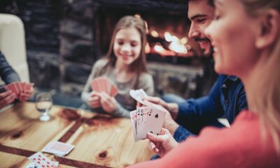 Giovane famiglia gioca a carte (© Depositphotos)